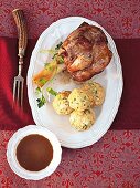 Veal shank with ciabatta dumplings in serving dish, overhead view