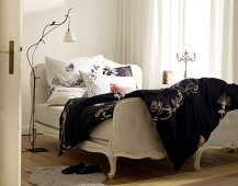 Single bed in white and black and white bedding with floral motifs