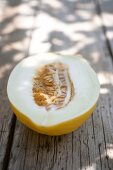 Halved honeydew melon on wooden surface