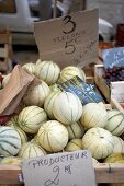 Close-up of charentais melons in wooden box at market