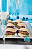 Meatballs, onion and arugula in sesame seed bun on tray