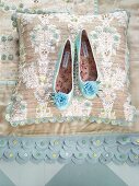 Ballerinas shoes on silk floral patterned pillows and blanket