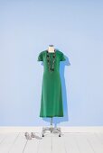 grünes Seidenkleid auf einem Kleiderständer