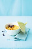 Sweet potatoes and coconut soup in a bowl with a lid