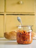 Sea buckthorn chutney in a preserving jar with a spoon in it
