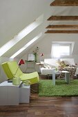 Wohnzimmer mit grünem Sessel und weißem Sofa, Dachschräge
