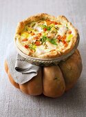 Close-up of pumpkin quiche with pine nuts and hard cheese on a large pumpkin