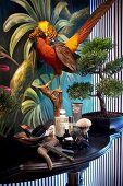 Various men fragrances beside bonsai tree and decorative birds on table