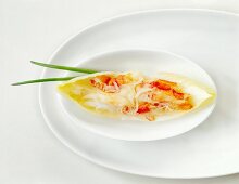 Crabmeat with chicory leaves and chives on serving dish, overhead view