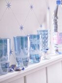 Blue and white drinking glasses lined up in hand-cut designs