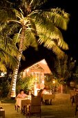 Tables laid on beach at dusk in Veligandu Island Resort, Maldives