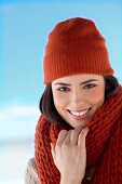 Portrait of beautiful woman wearing red woollen hat and scarf smiling