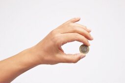 Euromünze, gehalten zwischen zwei Fingern
