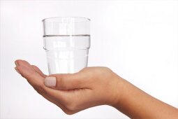 Glas Wasser auf einer Hand