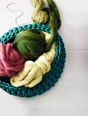 Colourful balls of wool in basket on white background