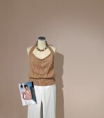 Overall knit halter top with white pants on mannequin