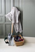 Knitted sweater on spade with wools in wooden basket
