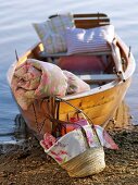 Boot am Ufer, Korbtasche, Decke und Kissen