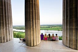 People sitting at Plateau Doric columns in The Walhalla against Danube river, Germany