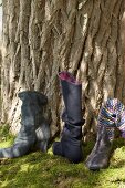 Three different types of boots made of recycled felt, wool and leather on moss