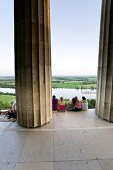 People sitting at Plateau Doric columns in The Walhalla against Danube river, Germany