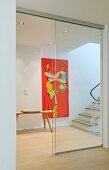 Hallway with staircase, artwork on wall and sliding glass door