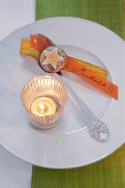 Gingerbread, lit candle and orange name tape on plate