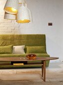 Green sofa, cushion, coffee table and hanging lamps in living room