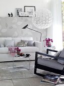 Leaf patterned white wallpaper, sofa, armchair and coffee table in living room