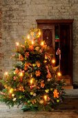 Christmas tree decorated with candles, gingerbread and small mannequins