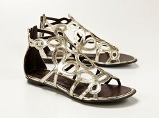 Close-up of Roman silver sandals on white background