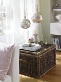 Living room with wicker box and silver pendant light fittings made of sheet metal