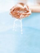 Close-up of water dripping from cupped hand of woman