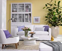 Living room with upholstered furniture, china cabinet and green plants