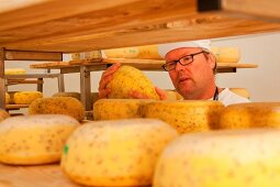 Close-up of man checking cheese on the shelf