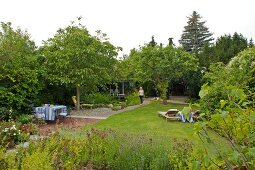 Garten mit Rasen, verschiedenen Sitzplätzen unter Bäumen, Nutzgarten