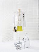 White long blazer and yellow narrow skirt on clothes stand