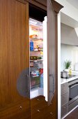 Modern kitchen with integrated refrigerator in wooden cabinet