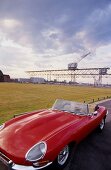 View of Red Jaguar E-type in front of port crane at Holmen, Copenhagen, Denmark