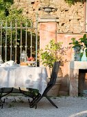 Oak dining table with chairs and cutlery outside Tuscan country house