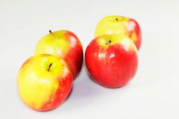 Close-up of four apples on white background