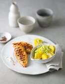 Grilled chicken breast with leek and potato salad on plate