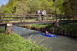 Man boating in river and people standing on bridge at Nature Park, Franconia, Switzerland