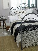 Black and white plaid bed sheet with crochet on iron bed