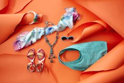 Shoes, cloth, bag and sunglasses in south sea style on orange background