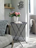 Round metal table with flower vase on top in living room