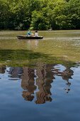 Couple on boat at Central park lake overlooking The Dakota, New York, USA