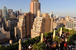 View of cityscape overlooking people sitting on rooftop bar at New York, USA