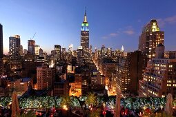 View of cityscape overlooking people sitting on rooftop bar at New York, USA