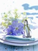 Gedeck dekoriert mit Dill und blauen Blüten, auf Gartentisch
